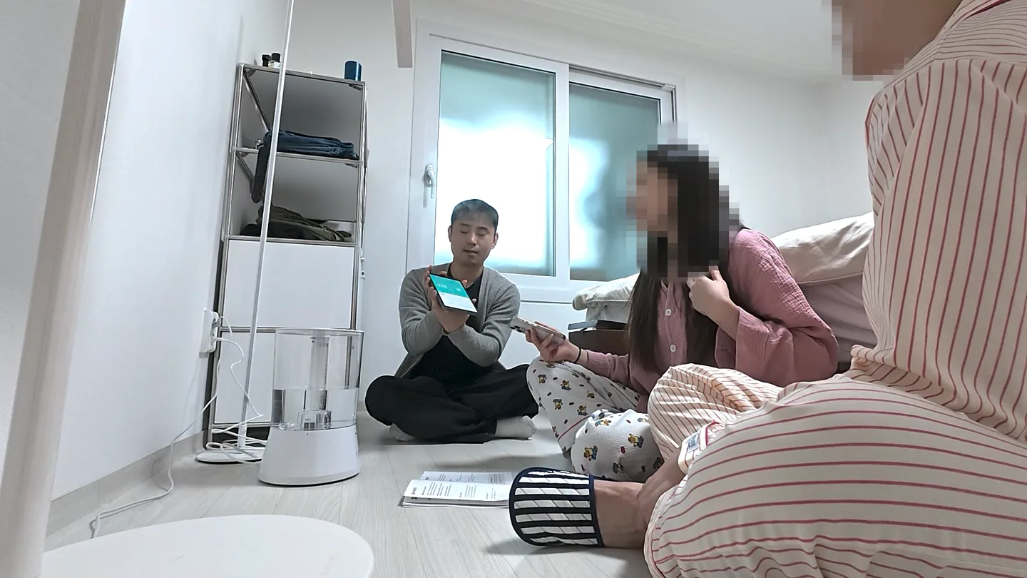 고객 집 방바닥에 앉아 휴대폰 앱 화면을 보여 주며 설치와 구간을 설명하는 김기원 총괄매니저와 듣고 있는 고객